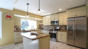A kitchen with a central island, stainless steel appliances, and light-colored cabinetry. - Across from Marina, Fishing, Watch the Sea Lions, Great Parking for Boats (Bodega Bay)