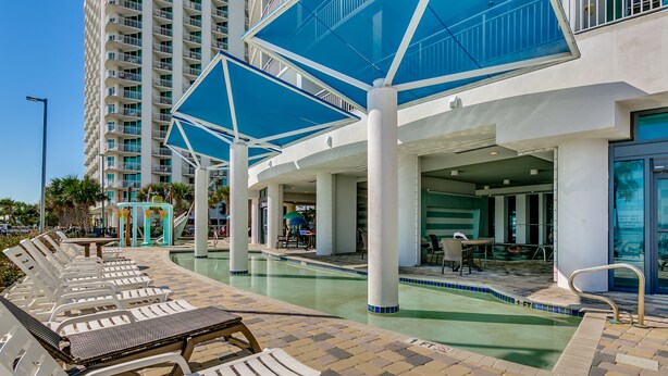 Zona junto a la piscina con sillones de descanso y piscina.