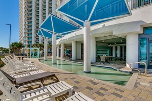 A poolside area with lounge chairs and a pool.