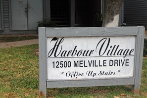 Señal de Harbour Village en 12500 Melville Drive, que indica la ubicación de la oficina en el piso superior.