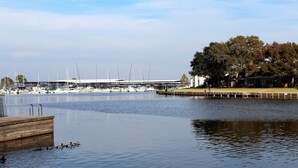 Un port de plaisance avec des bateaux amarrés, une jetée en bois et un bâtiment doté d’une zone abritée.