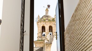 Una escalera que lleva a una puerta, con vista a un edificio histórico y una torre campanario.