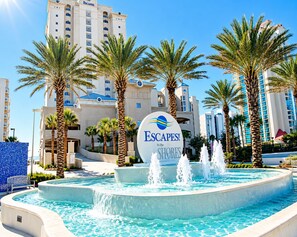 A hotel sign with a pool and palm trees. - Spacious Gulf-Front 4BR Condo | Sleeps 10 | Huge Balcony | Indoor & Outdoor Pools (Orange Beach)
