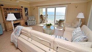 A spacious living room with a sofa, armchairs, a TV, and a balcony with a view of the ocean. - Relax and Catch a couple of fish! 🎣 ~ There is something for everyone! (Orange Beach)