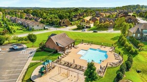 A residential area with a swimming pool, a playground, and a parking lot.