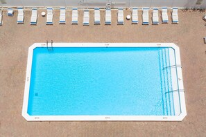 A rectangular swimming pool with a white border, depth markers at 3, 4, and 6 feet, and a ladder leading into the pool.