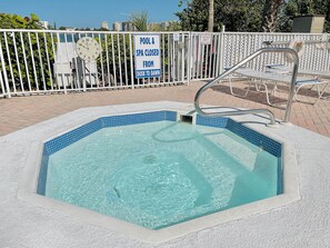 Una piscina con un cartel que indica que está cerrada desde el anochecer hasta el amanecer.