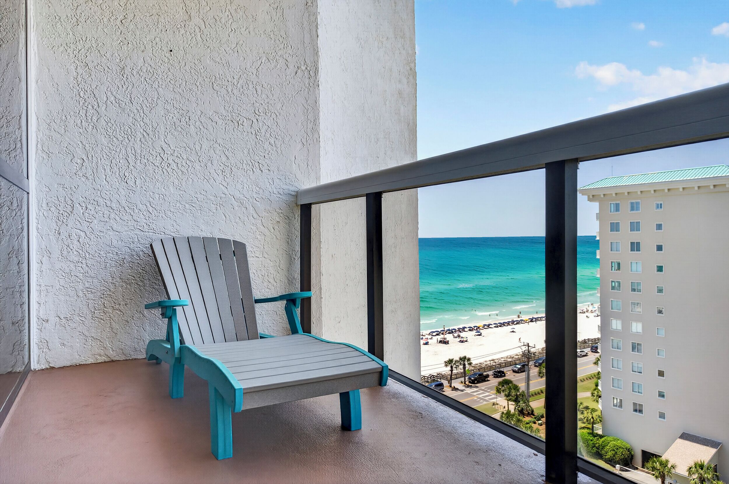 A balcony with a view of a beach and a building.