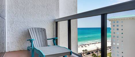 A balcony with a view of a beach and a building.