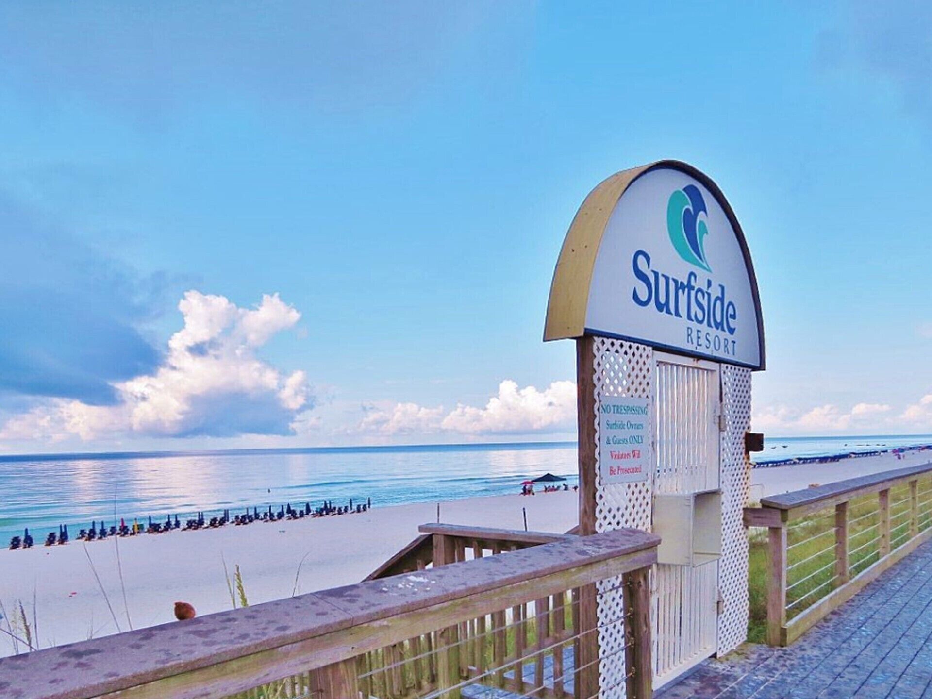 A sign for Surfside Resort with a view of the beach and ocean.