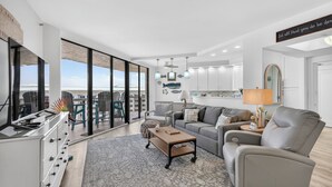 Ein modernes Wohnzimmer mit einer Couch, einem Couchtisch und Blick durch große Fenster.