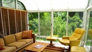 Ein modernes Wohnzimmer mit einer Couch, Sesseln und einem Couchtisch.