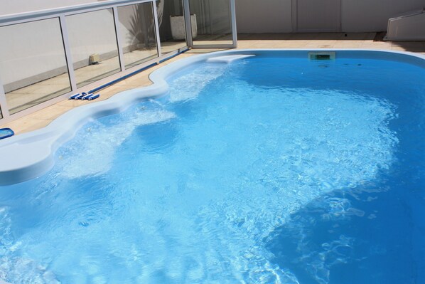 Alberca al aire libre, sombrillas en la alberca y camastros 