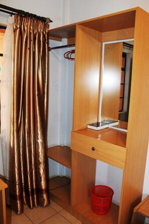 Ein kleines Zimmer mit einem Holztisch, einem Spiegel und einem roten Korb.
