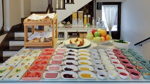 Un buffet de petit-déjeuner proposant divers plats et une corbeille de fruits.