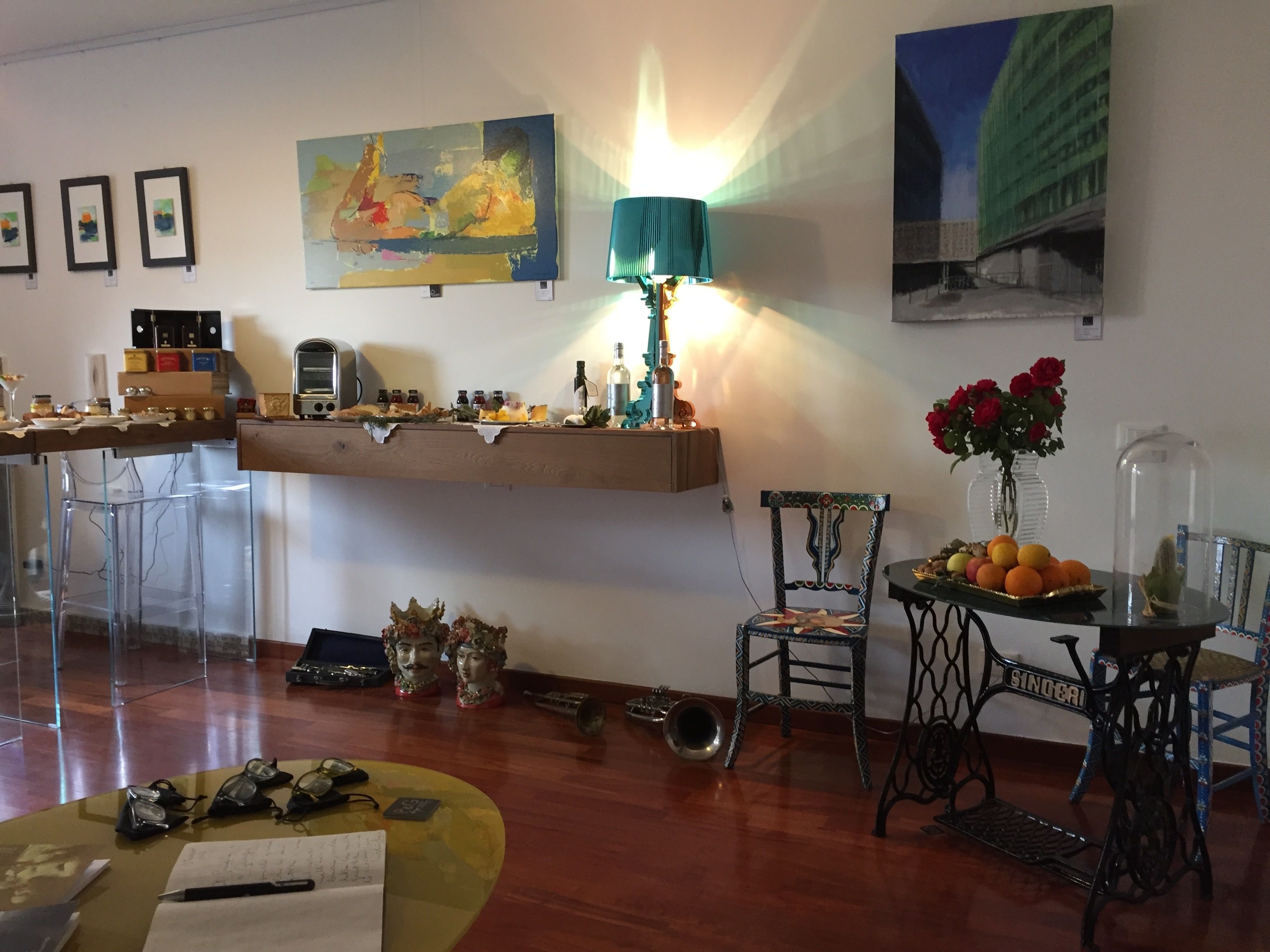 Une pièce comprenant une table à manger en bois, une chaise, une machine à coudre, une lampe et une étagère sur laquelle sont disposés divers objets.