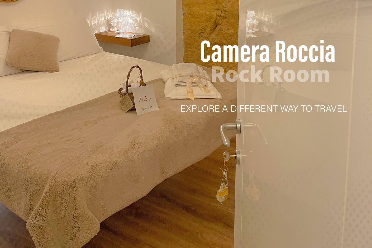 Ein gemütliches Zimmer mit einem Bett, einem dekorativen Spiegel und einer Wand mit besonderer Struktur.