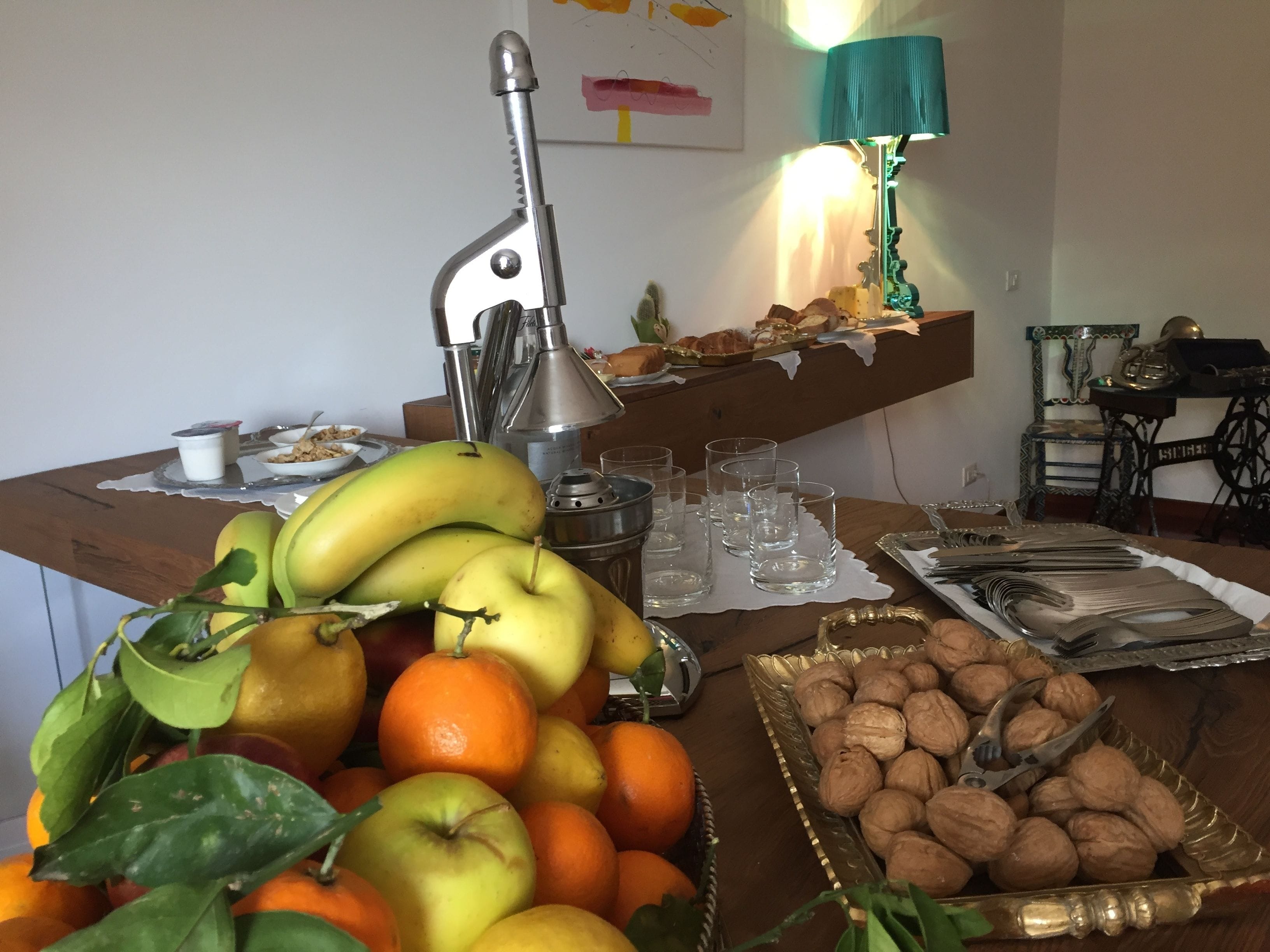A buffet table with fruits, nuts, and glasses.