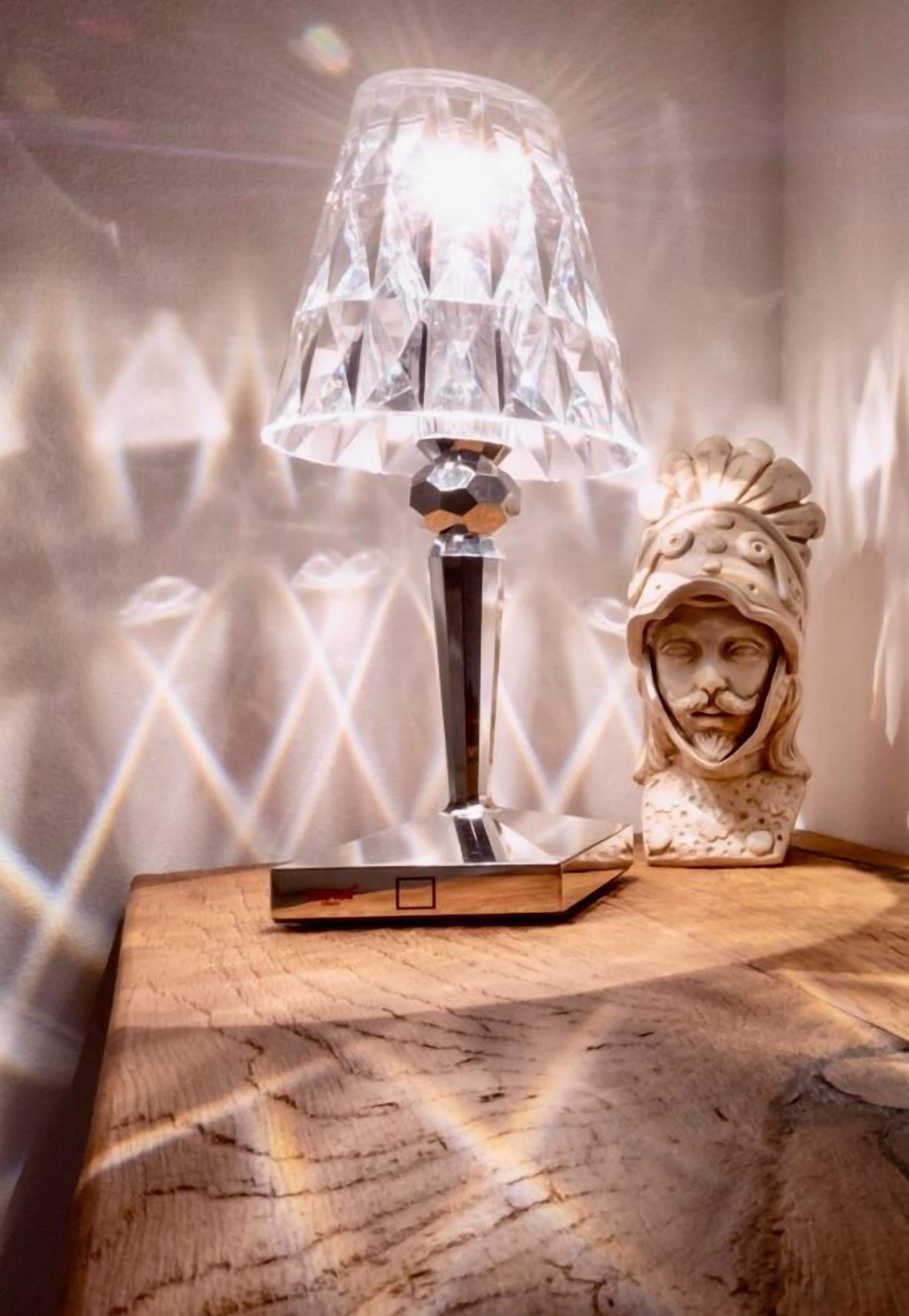 A table with a crystal lamp and a decorative object.