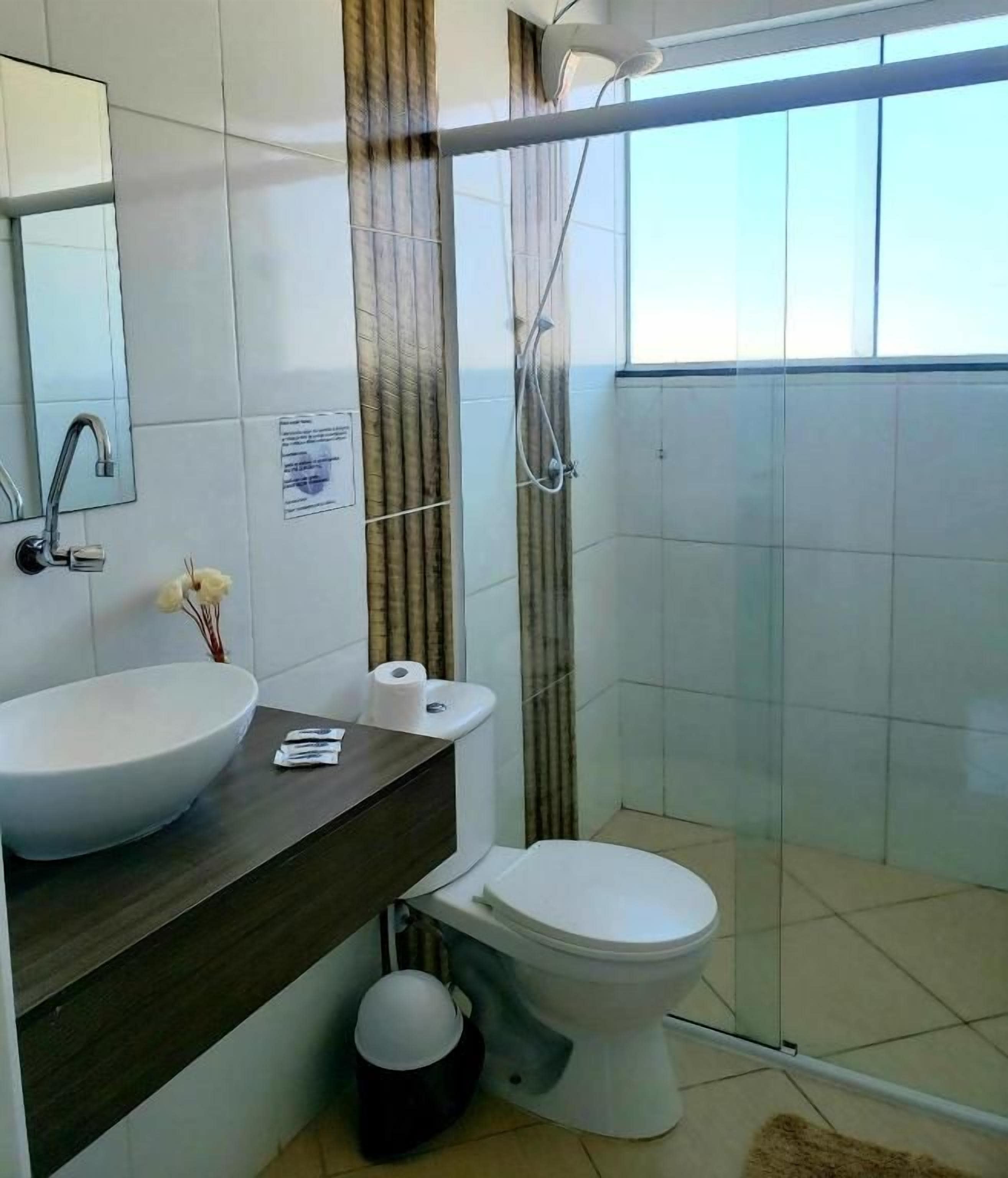 Un baño con lavamanos grande, inodoro y ducha.