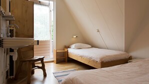 Un dormitorio con cama alta, un escritorio de madera y una silla.