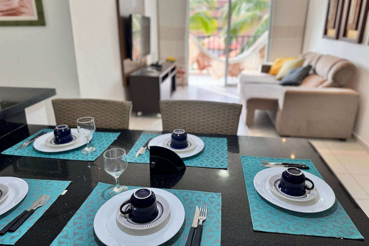 A dining area with a table set for four, including plates, cutlery, and glasses.