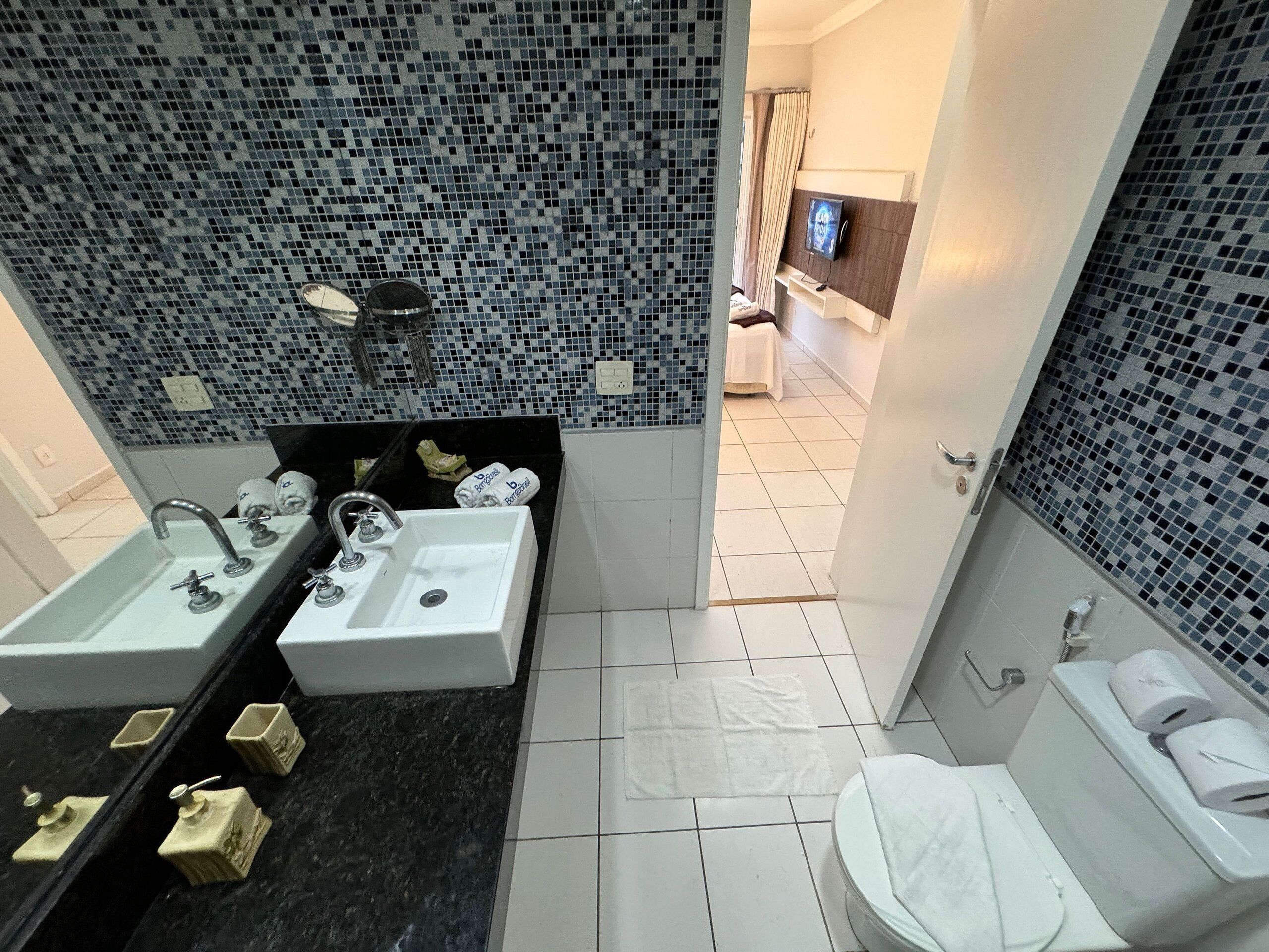 A bathroom with two sinks, a toilet, and a shower.