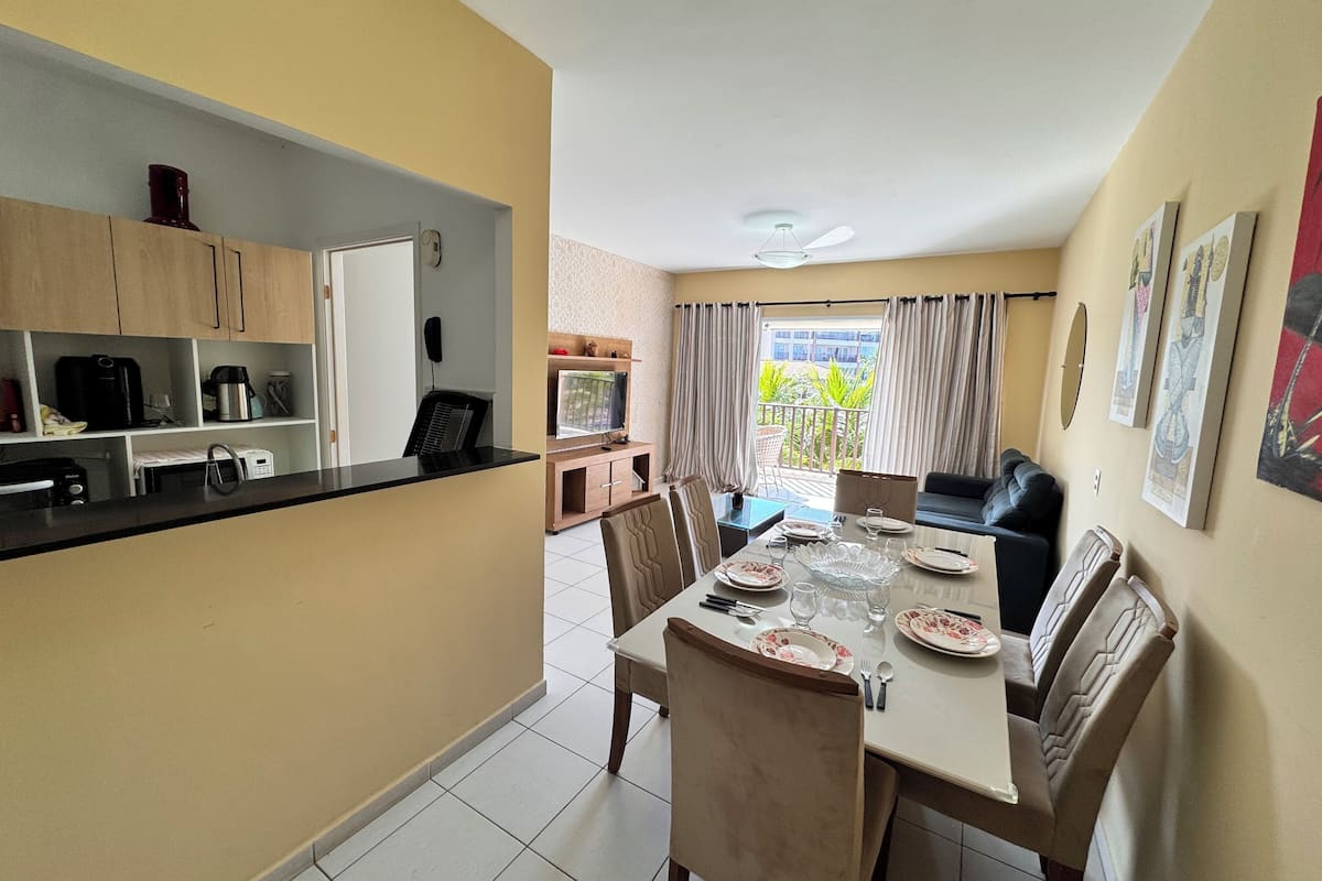 A compact kitchen with modern appliances and a dining area with a table set for four.