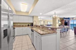 Enjoy cooking in this well-lit kitchen with a large island, stainless steel appliances, and a dining area.