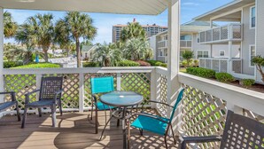 A covered outdoor area with a table and chairs, surrounded by a white lattice fence. - Shorehaven II Beach Resort (North Myrtle Beach)