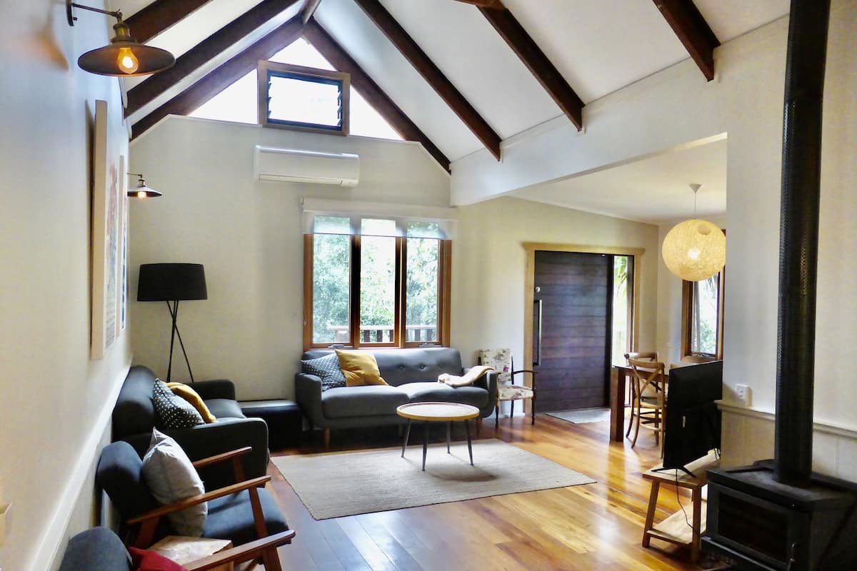 A spacious living room with a sofa, a round coffee table, and a fireplace.