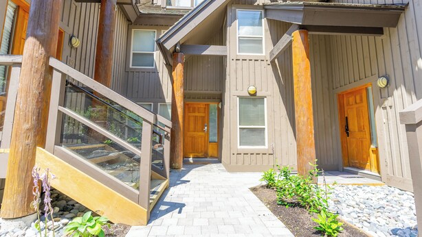 A wooden building with a covered walkway, a wooden door, and a window. - Painted Cliff 18  Ski-in, Ski-out Luxury with serene mountain view, sleeps 7 (Whistler)