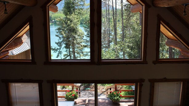 A room with large windows overlooking a forest and a lake. - 1 BR+ Loft, Log Cabin With Lakeview, Sleeps 4, 5 mins to Glacier (West Glacier)