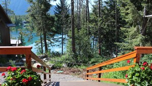 A wooden deck with a view of a lake and forest. - 1 BR+ Loft, Log Cabin With Lakeview, Sleeps 4, 5 mins to Glacier (West Glacier)