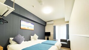 Een hotelkamer met twee bedden, een televisie, een stoel en een schilderij aan de muur.