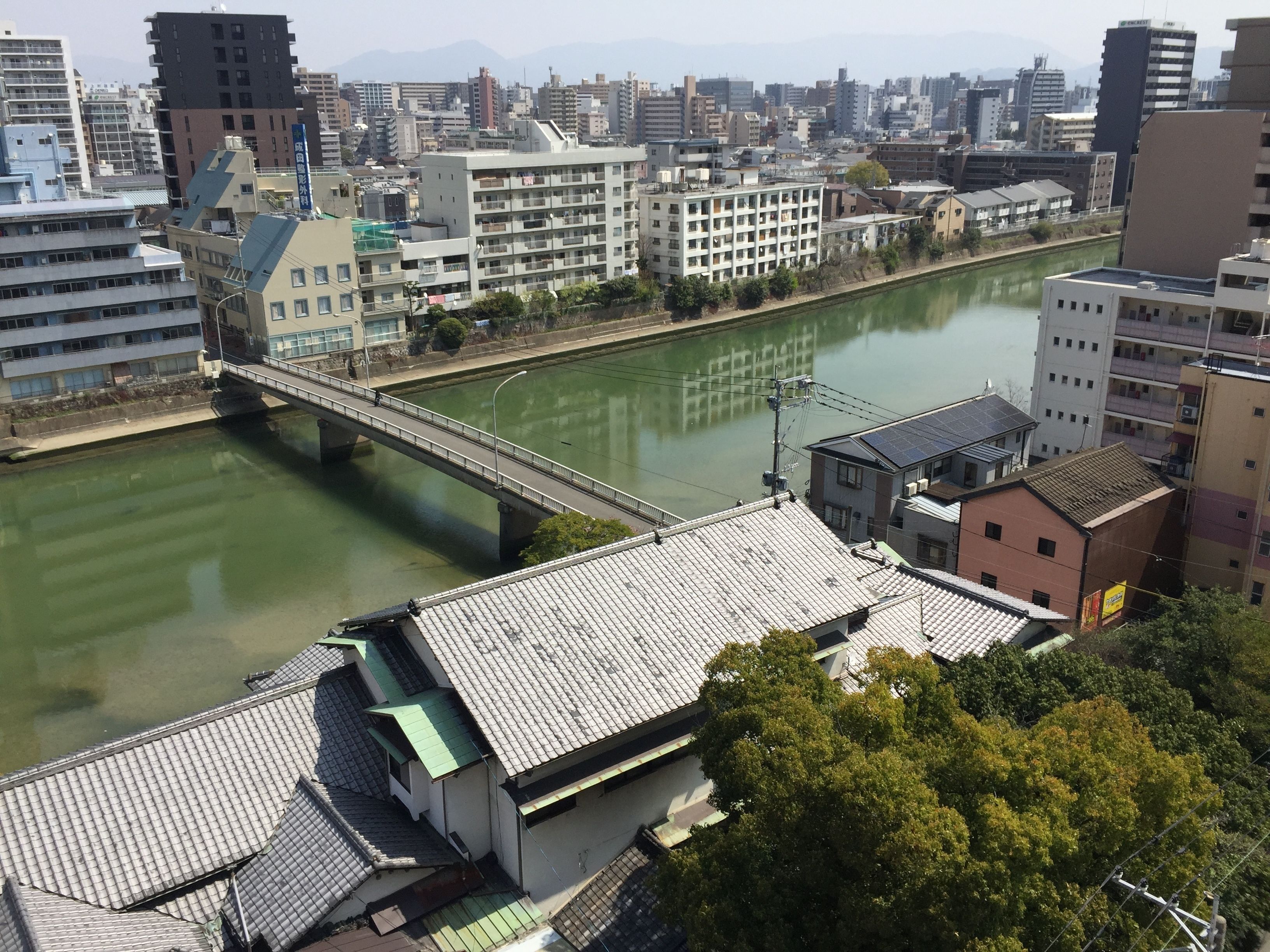 Un paisaje urbano con un río, edificios y un puente.