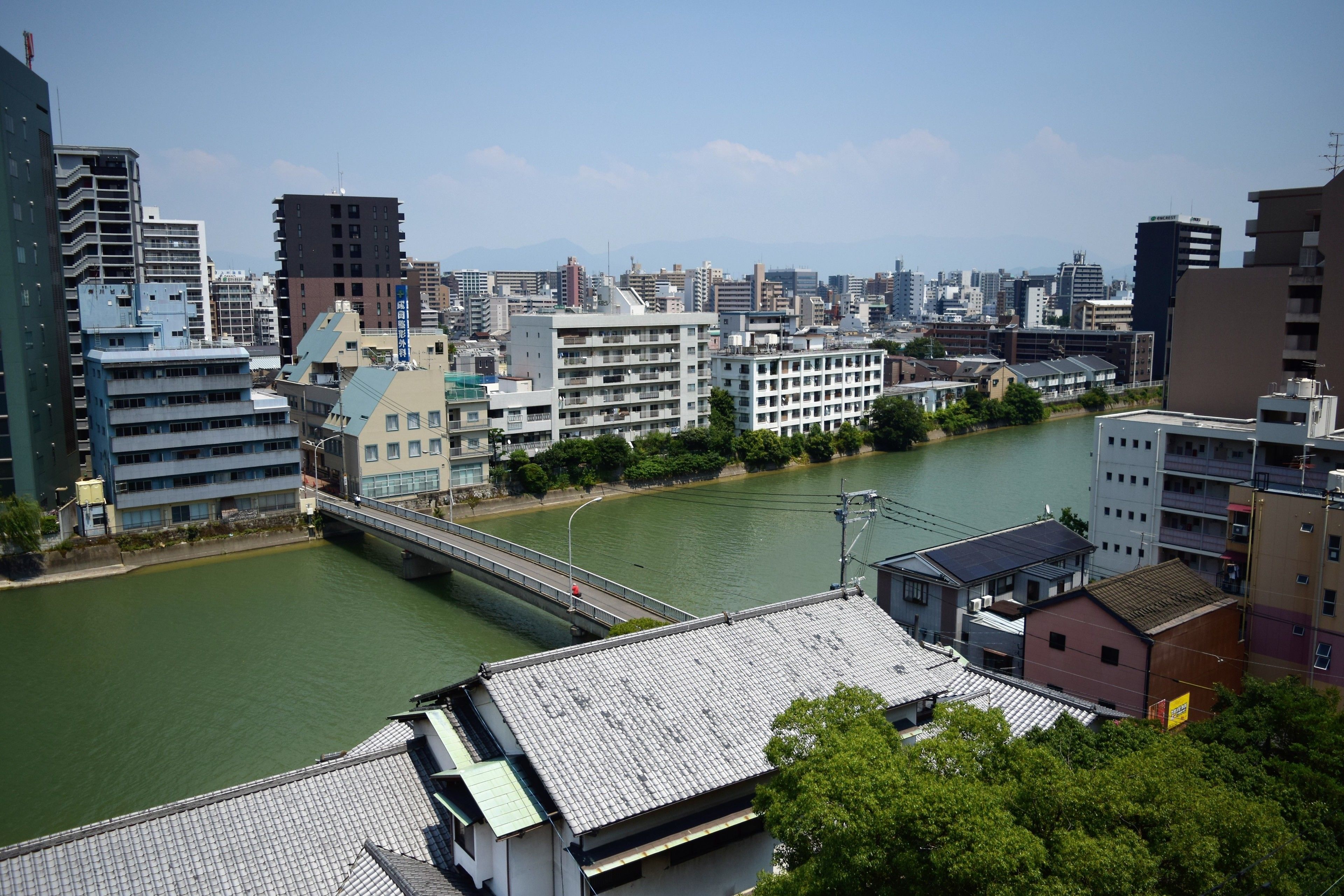 A cityscape with a river, buildings, and a bridge.