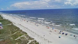 A beach with a wooden walkway and a pier extending into the ocean. - Sunrise Pointe Oceanfront Resort (North Myrtle Beach)