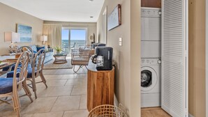 A modern living room with a sofa, chairs, a coffee table, and a view of the ocean. - Sea Cloisters II Ocean Front Beach Retreat (North Myrtle Beach)