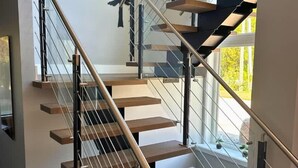 A modern staircase with glass railings and wooden steps. - Indoor Pool & Hot Tub, Steps to Ski Lift (Blue Mountains)