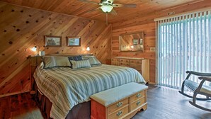 A wooden cabin bedroom with a bed, dresser, rocking chair, and ceiling fan. - Cozy Home w/ Patio Near Yosemite National Park! (Mariposa)