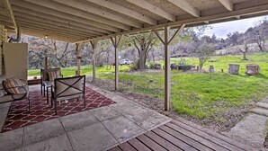 A covered patio with outdoor seating, a view of a grassy yard, and a wooden deck. - Cozy Home w/ Patio Near Yosemite National Park! (Mariposa)