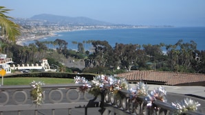 A coastal view with a beach, palm trees, and a building with a tiled roof. - Dana Point Dream Home with White Water Ocean View (Permit #STR14-0084) (Dana Point)