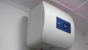 A white air conditioning unit mounted on a wall with a blue label. - Ashley Hills (Nuwara Eliya)