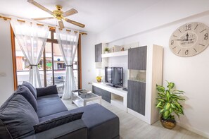 A modern living room with a sofa, TV, and a clock on the wall. - Altemar 2A004 totally refurbished (Playa de Las Americas)