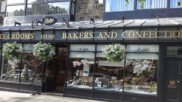 A storefront with signs reading "Bettys Tea Rooms" and "Bakers and Confectionery," established in 1919. - Character Cottage in Haworth. Come and Enjoy Yorkshire...Yours To Discover! (Haworth)