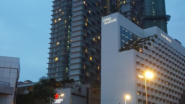 Een hotel met meerdere hoge gebouwen, waaronder een met een opvallend rood-wit logo.
