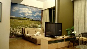 Een gezellige kamer met een bed, een televisie, een klein tafeltje en een stoel.