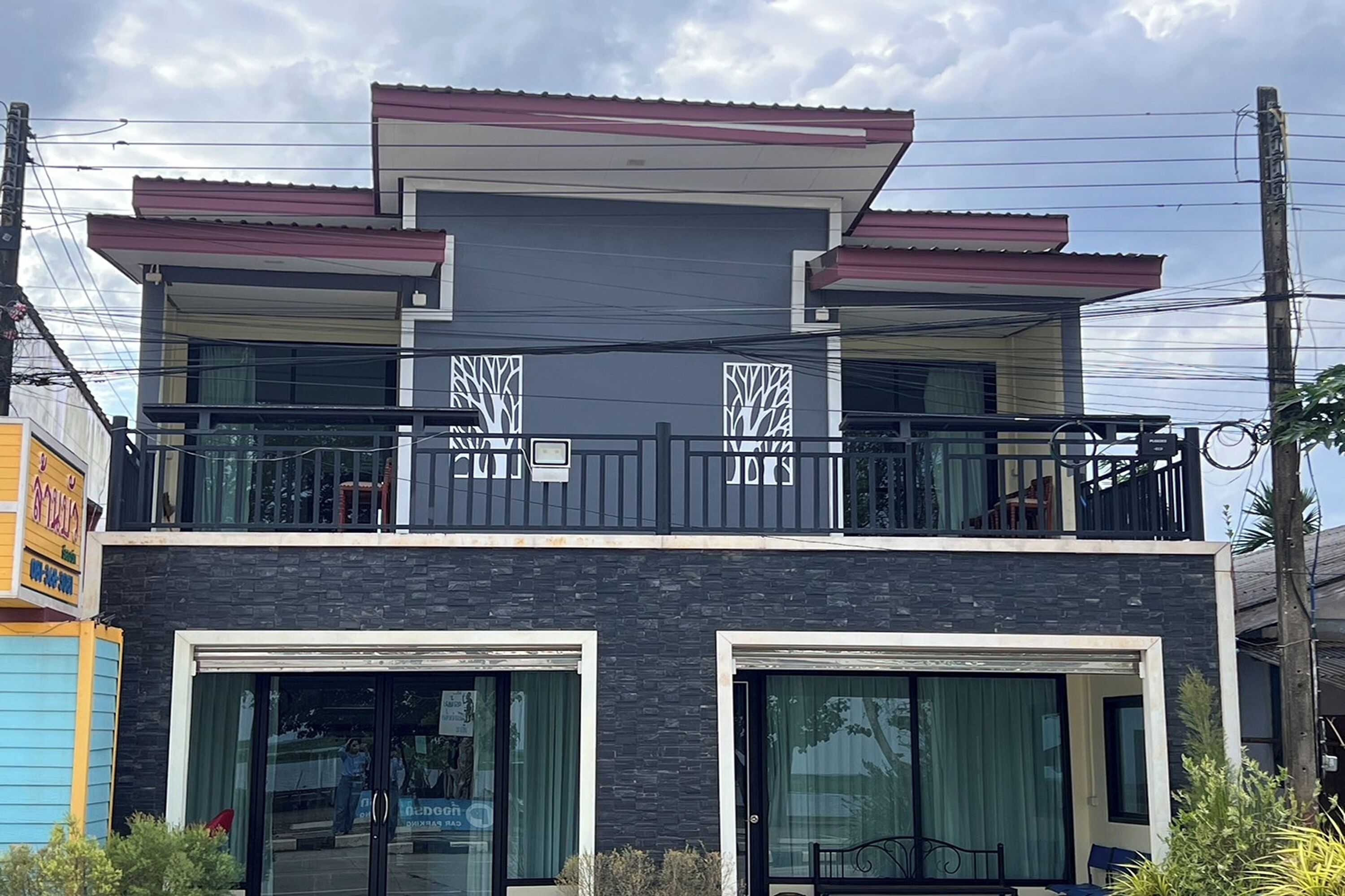 A modern two-story building with large windows and balconies.