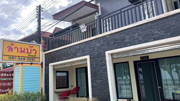 A building with a balcony, a signboard, and a door.